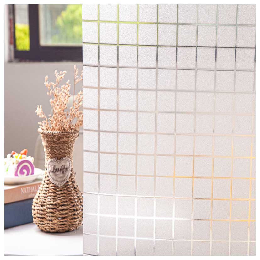 Một bình hoa bằng mây đựng hoa khô đặt bên cạnh những cuốn sách xếp chồng. Bên cạnh đó, một vách ngăn bằng kính mờ có họa tiết Decal ô vuông mờ một phần che khuất căn phòng nhưng vẫn cho phép ánh sáng lọt vào.