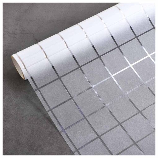 Một cuộn decal mờ hình vuông, có hoa văn lưới gồm các ô vuông trong suốt và mờ, được cuộn một phần trên bề mặt màu xám.